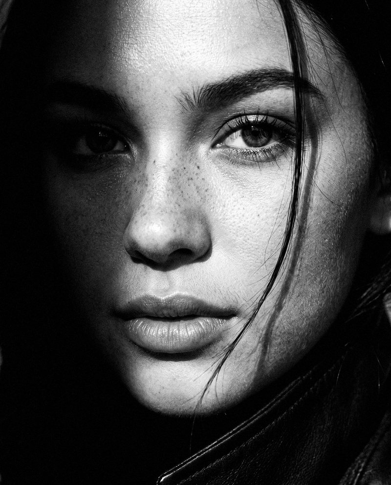 Nova Rai in a close portrait with half her face in shadow, in black and white