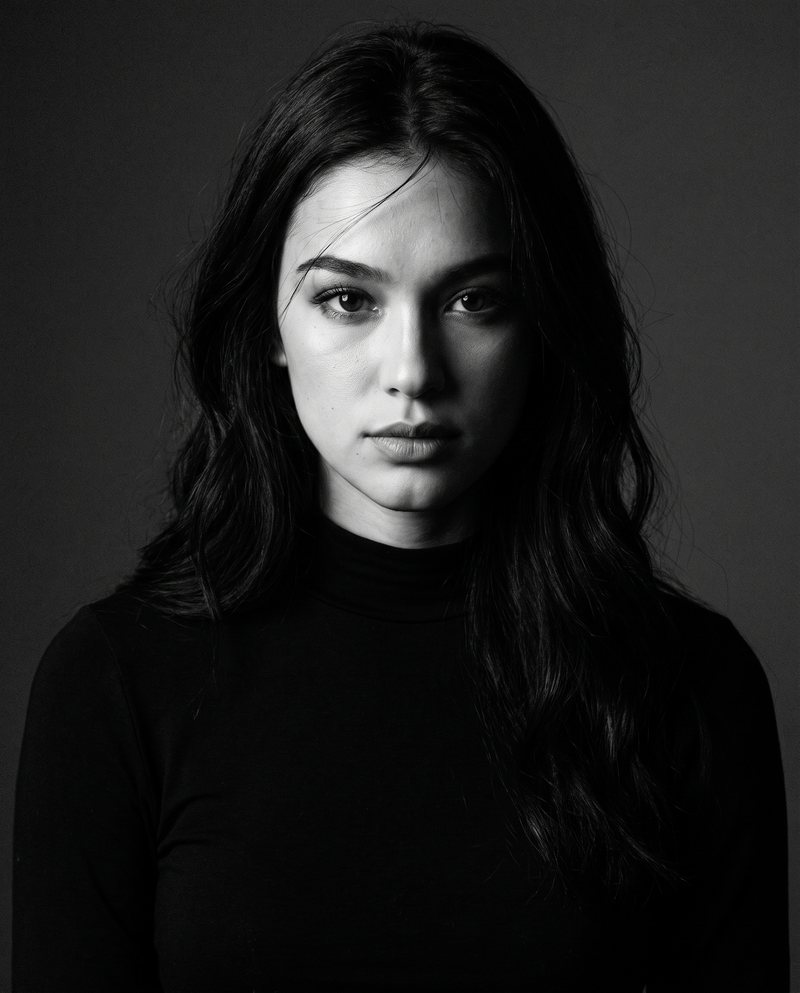 Nova Rai in a serious portrait lit from the side, in black and white