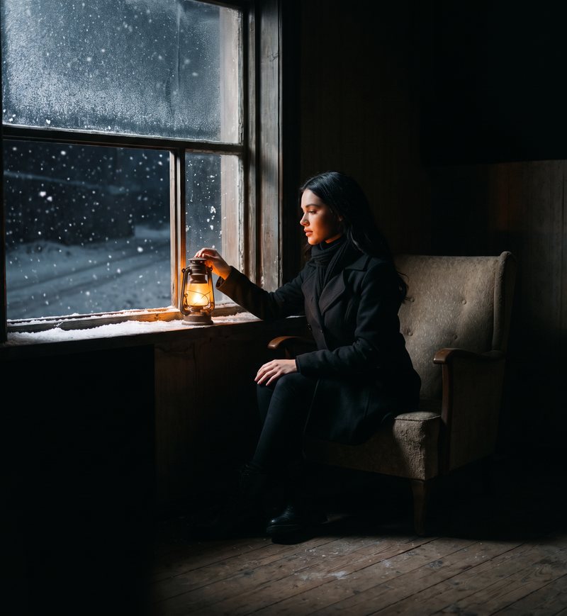 Nova Rai setting a lantern on the sill of a snowy window